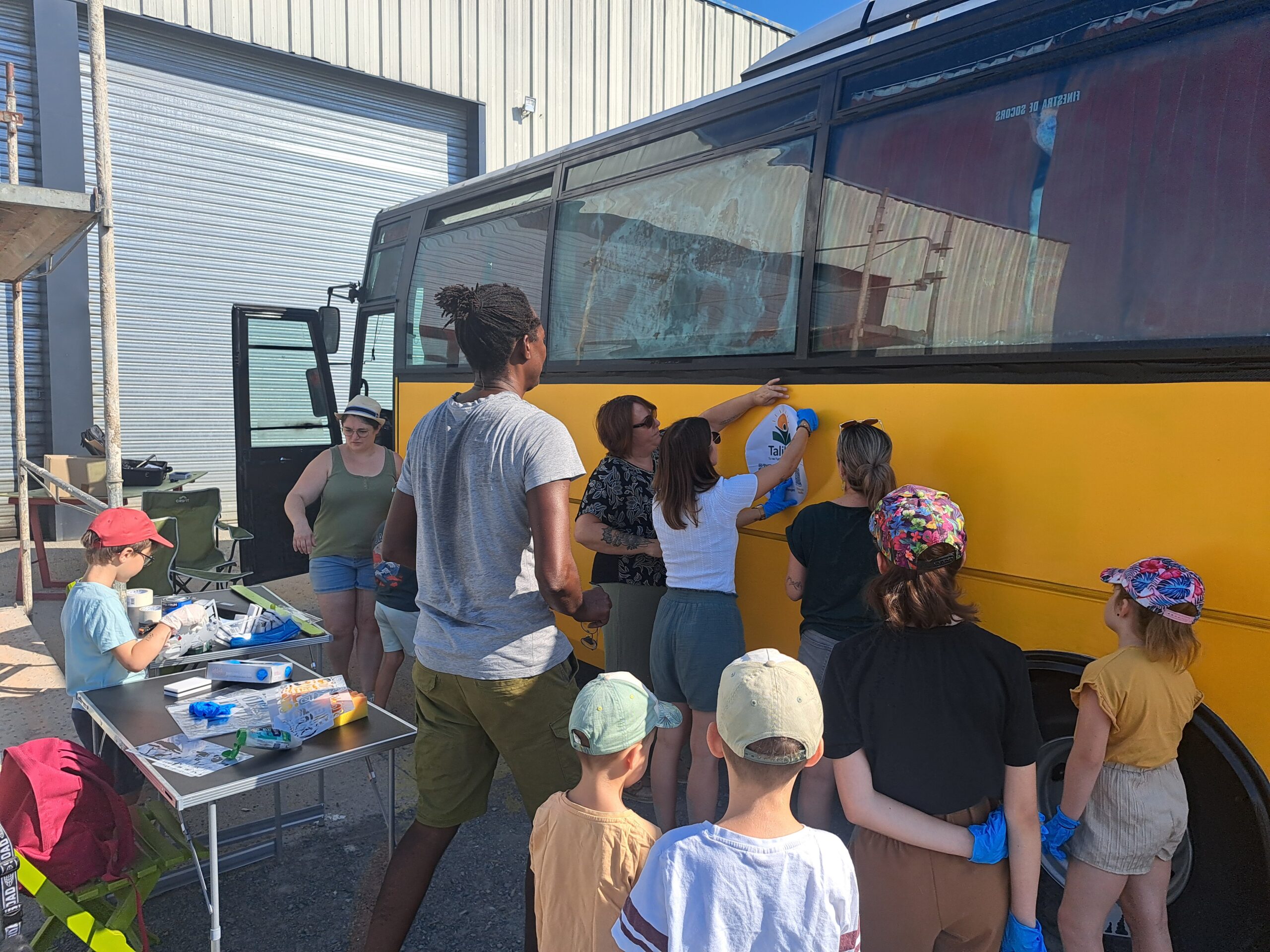 Enfants et bénévoles réunis autour du bus TalibéE