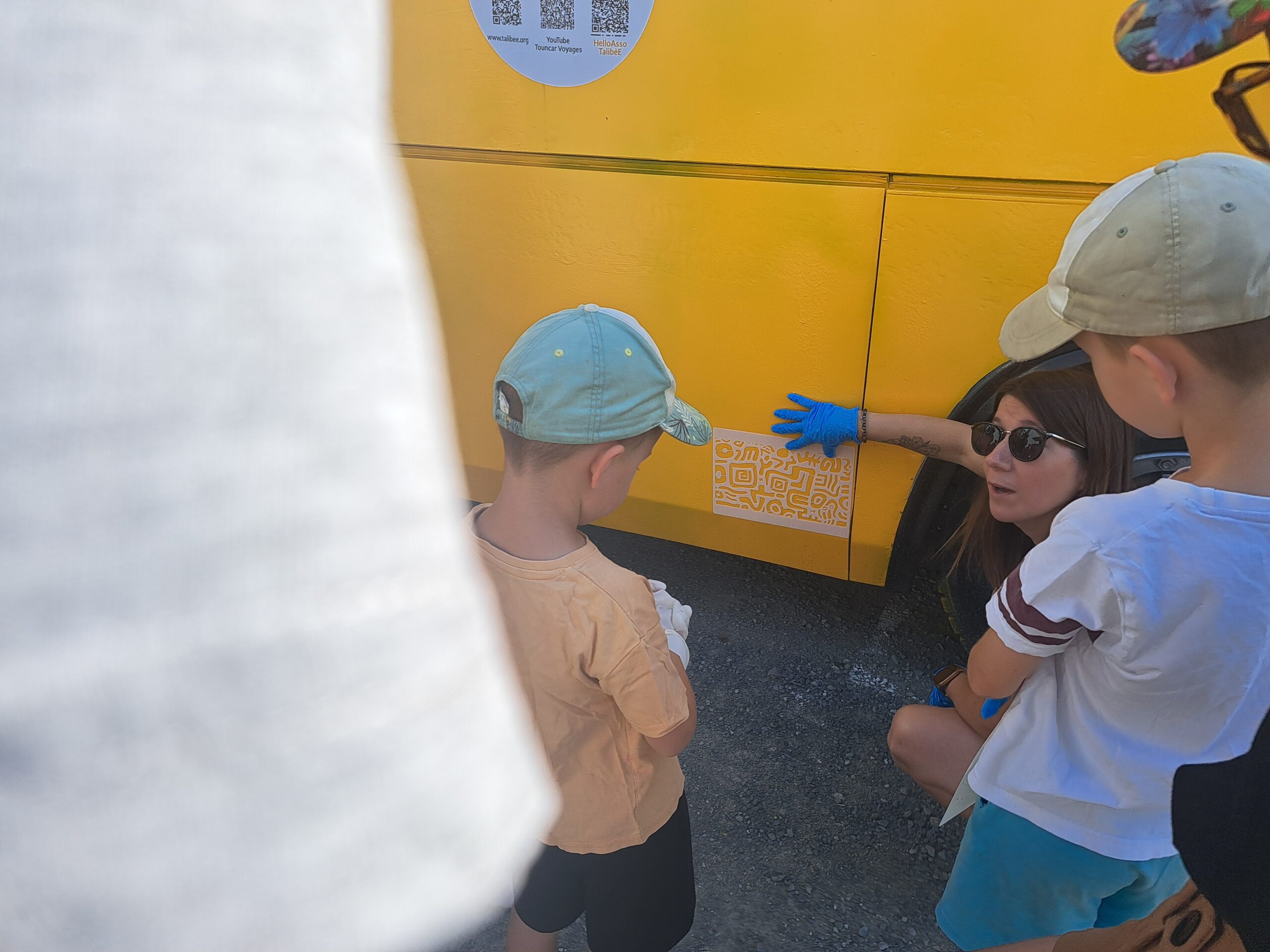 Des enfants participent à la décoration du bus